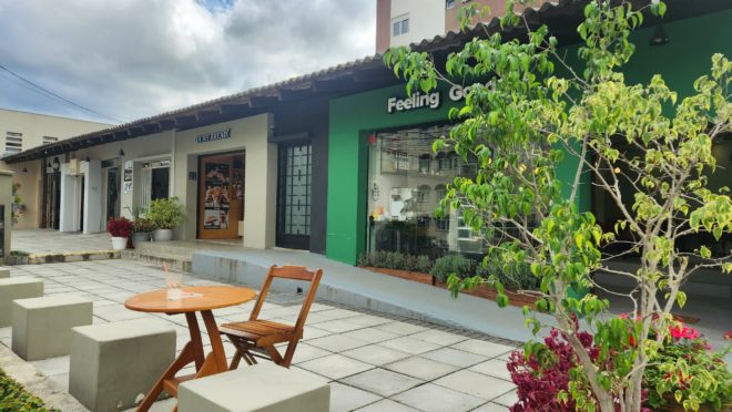 Fachada de uma loja de rua recém-inaugurada, com mesa e cadeira na calçada